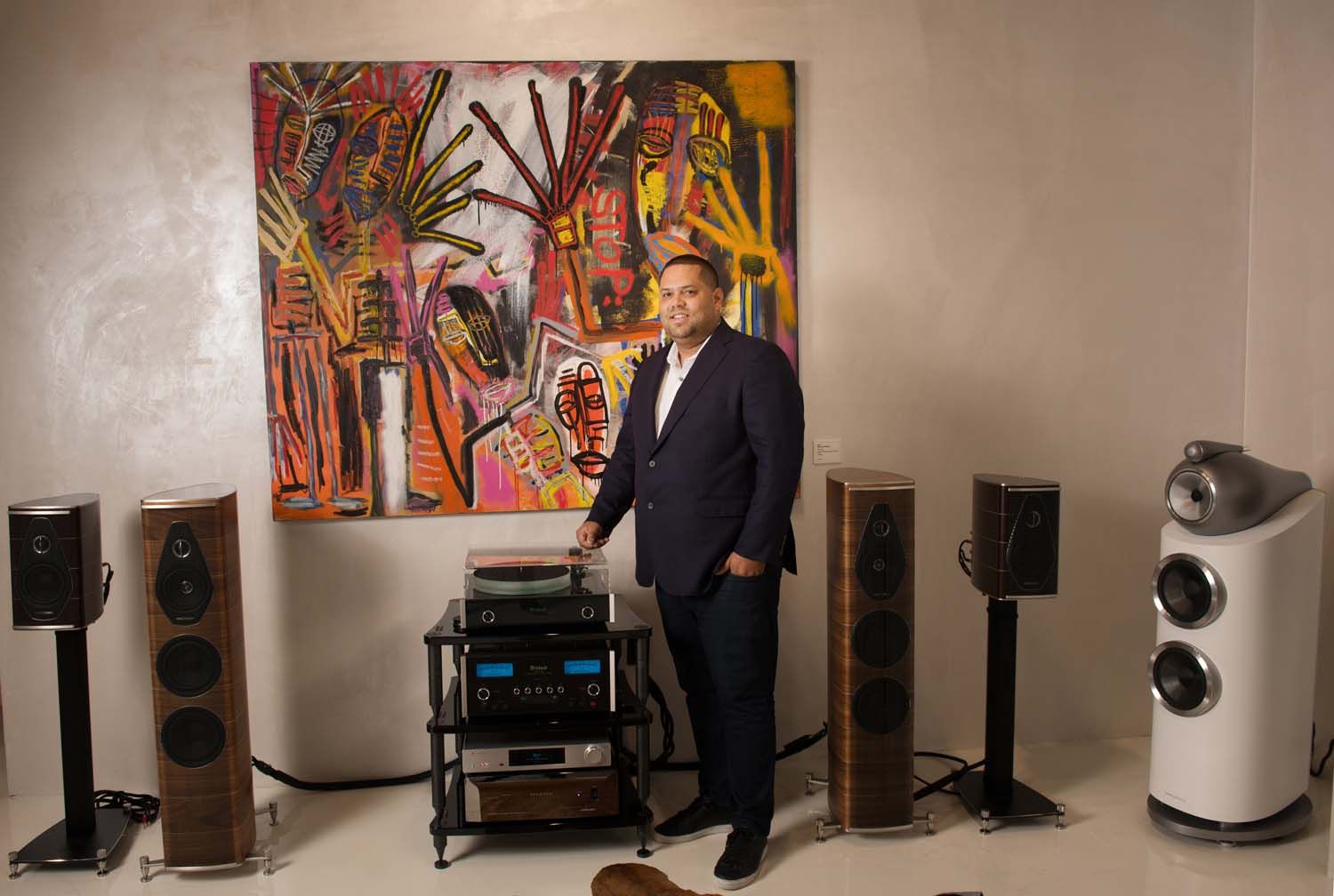 man standing next to high performance audio equipment